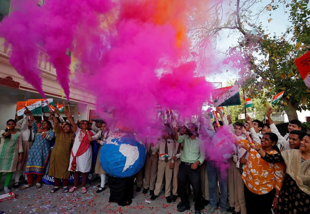 Teachers and students release coloured smoke as they celebrate after India shot down one of its satellites in space with an anti-satellite missile in a test, inside their school premises in Ahmedabad, India, March 27, 2019. Reuters/Amit Dave