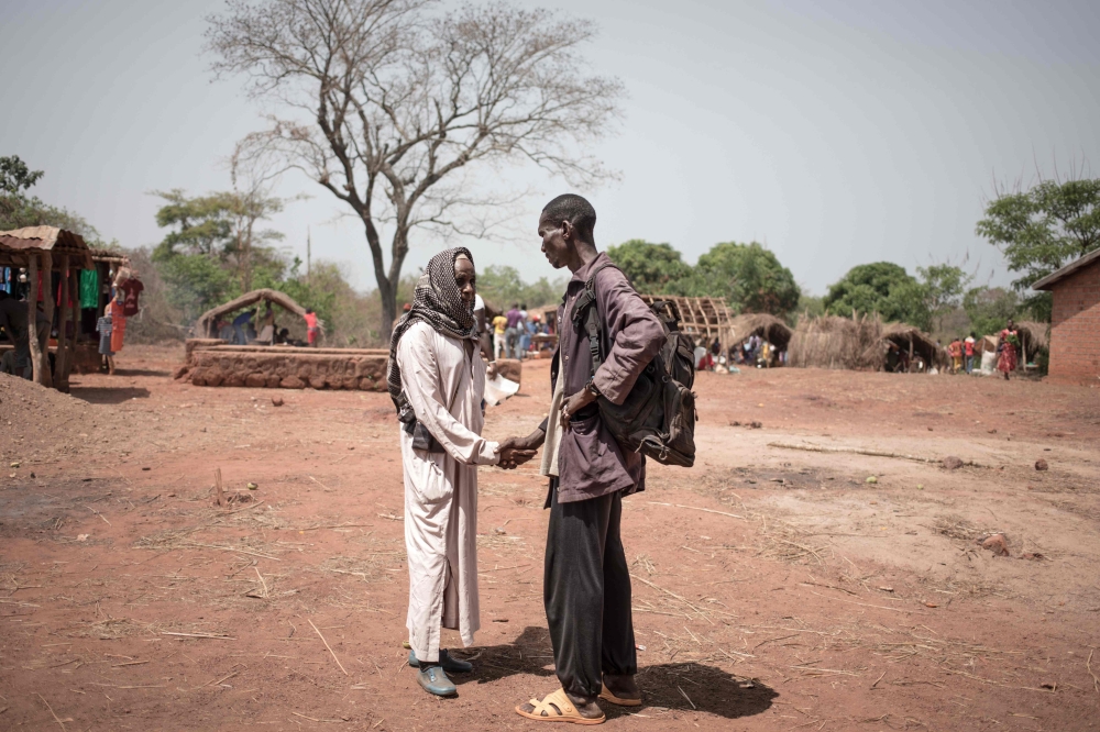 Awatche's self-defence leader shakes hands with a Fulani breeder, on March 17, 2019.  AFP / Florent Vergnes 