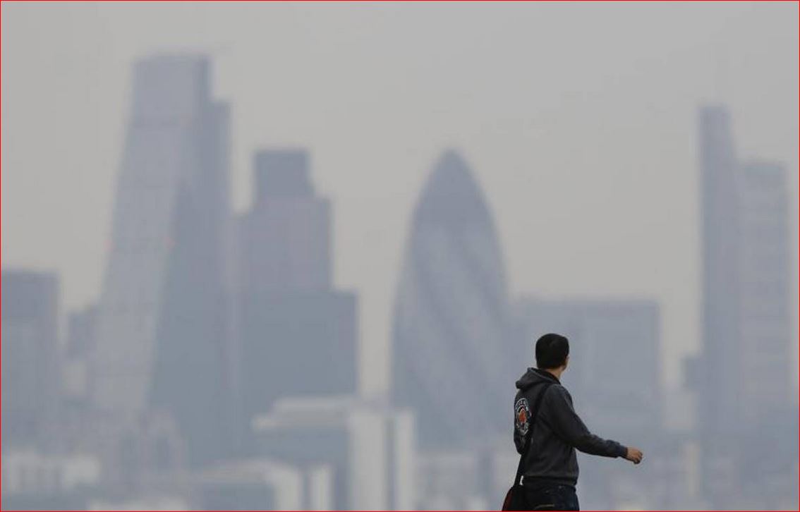 A man walks through Greenwich Park as a haze of pollution sits over the London skyline April 3, 2014. Reuters/Luke MacGregor