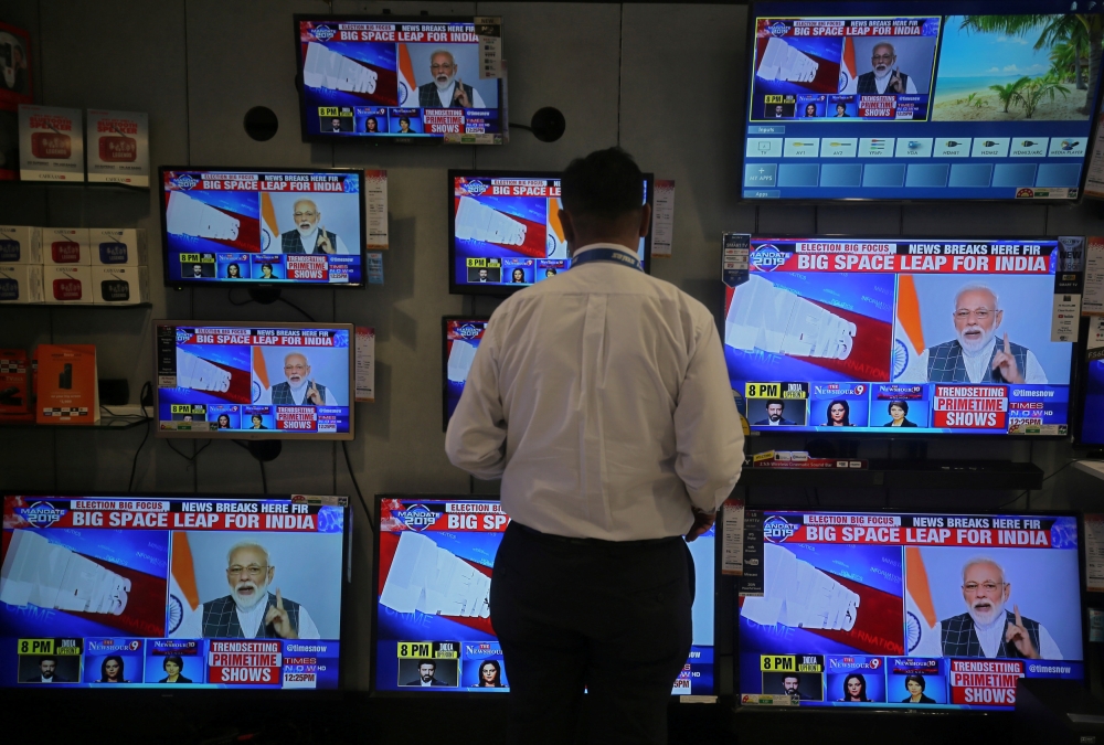 A salesman watches Prime Minister Narendra Modi addressing to the nation, on TV screens inside a showroom in Mumbai, India, March 27, 2019. Reuters/Francis Mascarenhas