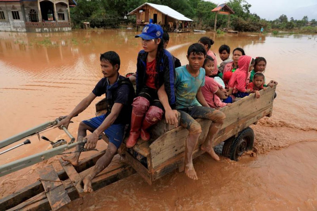 People sit on a locally made vehicle as they travel during the flood after the Xepian-Xe Nam Noy hydropower dam collapsed in Attapeu province, Laos July 26, 2018. Reuters/Soe Zeya Tun