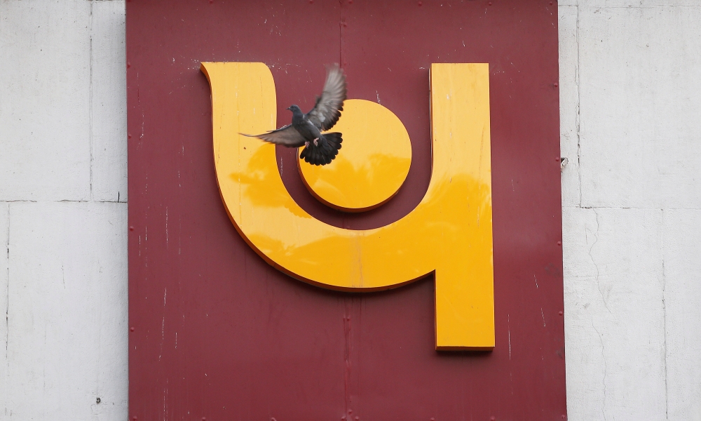 A pigeon flies past the logo of Punjab National Bank outside a branch of the bank in New Delhi, India, February 15, 2018. Reuters/Adnan Abidi