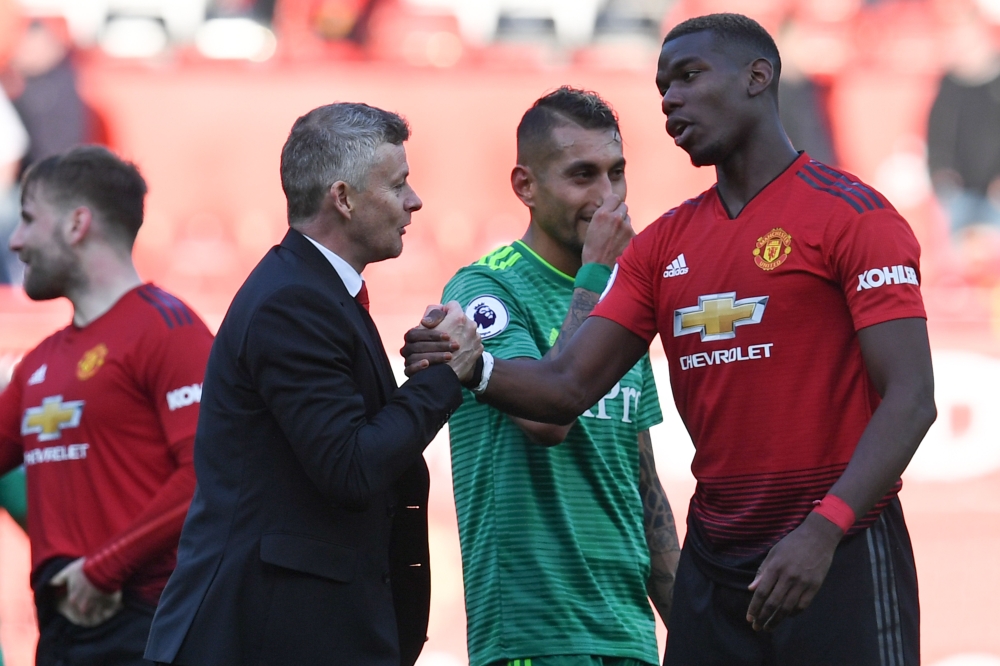 Manchester United's Norwegian manager Ole Gunnar Solskjaer (L) shakes hands with Manchester United's French midfielder Paul Pogba (R) after the final whistle of the English Premier League football match between Manchester United and Watford at Old Traffor