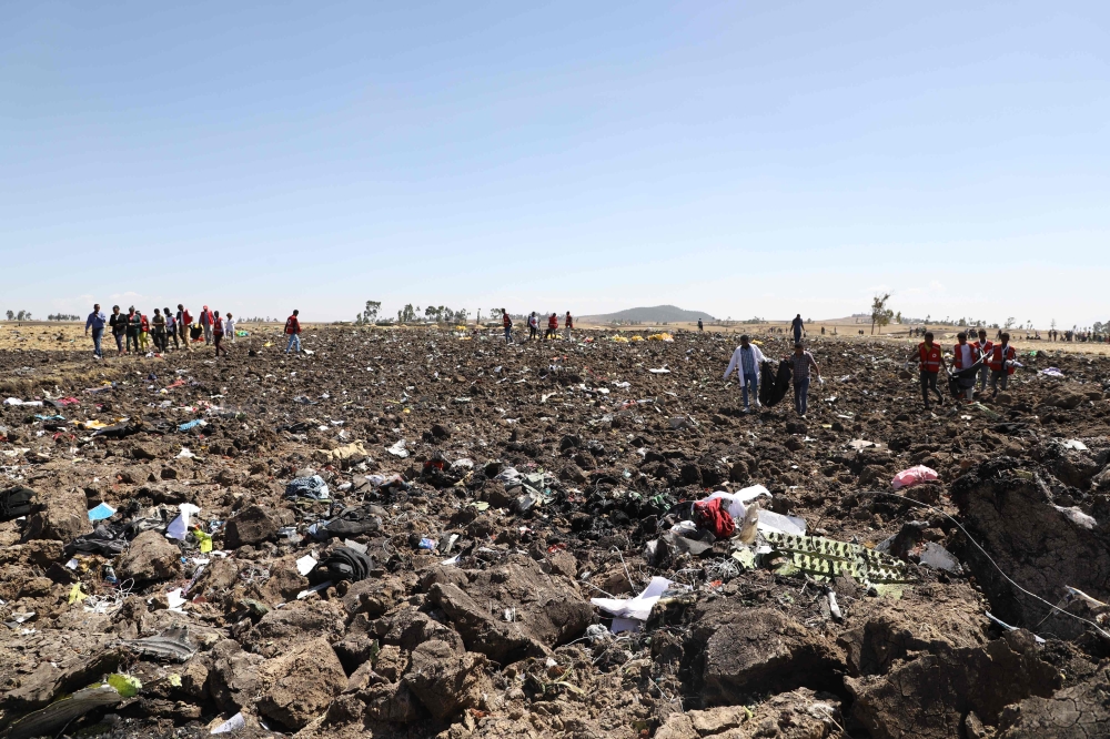 FILE PHOTO: Rescue teams collect bodies in bags amid debris at the crash site of Ethiopia Airlines near Bishoftu, a town some 60 kilometres southeast of Addis Ababa, Ethiopia. AFP / Michael TEWELDE
