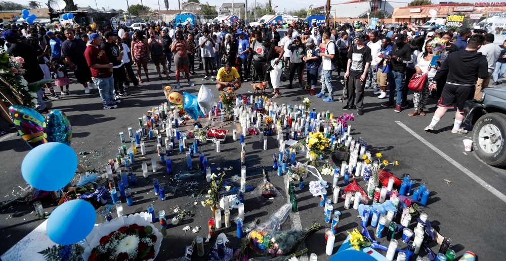 People gather around a makeshift memorial for Grammy-nominated rapper Nipsey Hussle who was shot and killed outside his clothing store in Los Angeles, California, U.S., April 1, 2019. REUTERS/Mario Anzuoni