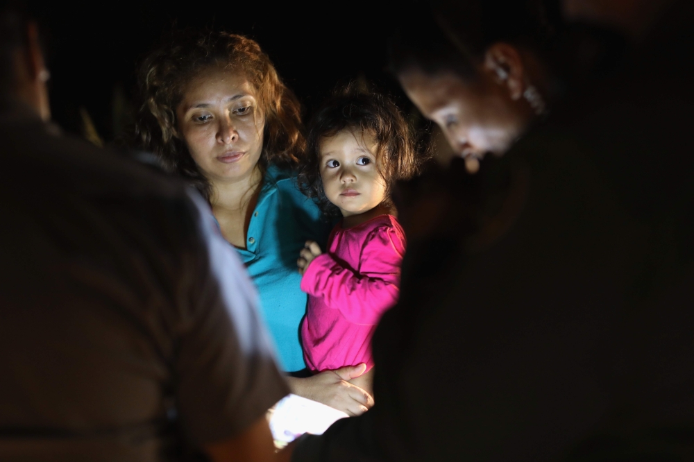 Central American asylum seekers including a Honduran girl, 2, and her mother near the US-Mexico border in McAllen, Texas on June 12, 2018. AFP / Getty Images North America / John Moore