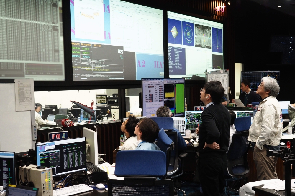 In this handout photograph taken and released by the Institute of Space and Astronautical Science (ISAS) of Japan Aerospace Exploration Agency (JAXA) on April 4, 2019, researchers and employees receive data in the control room in Sagamihara, which confirm