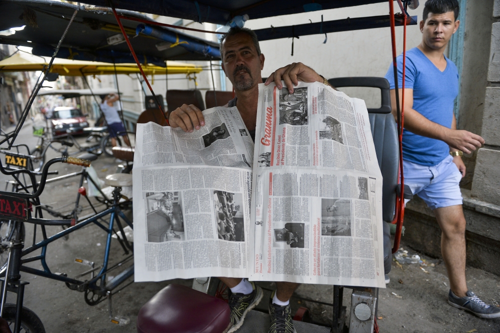 A man shows a two-sheet edition of Cuban official newspaper Granma on his bicitaxi in Havana, on April 5, 2019. AFP / YAMIL LAGE