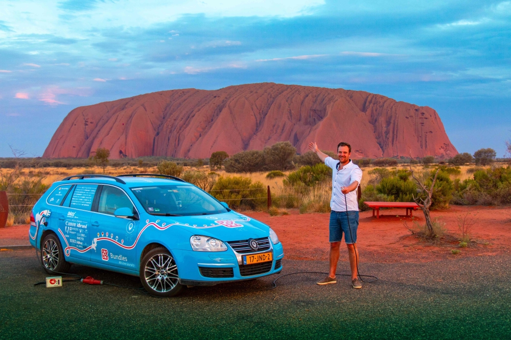 In this handout photo taken on December 31, 2018 and released on April 7, 2019 from Dutch driver Wiebe Wakker (C-R) shows him at Uluru in the Northern Territory with his retrofitted station wagon nicknamed 