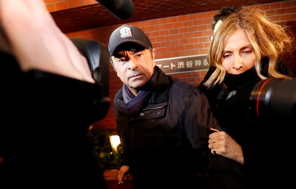 FILE PHOTO: Former Nissan Motor Chairman Carlos Ghosn accompanied by his wife Carole Ghosn, arrives at his place of residence in Tokyo, Japan, March 8, 2019. REUTERS/Issei Kato
