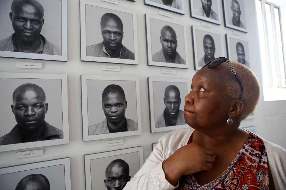 Pulane Koboekae looks at a picture of her older brother Richard Motsoahae during a tour of the gallows at Kgosi Mampuru Correctional Facility in Pretoria, South Africa on August 15, 2018. AFP / Phill Magakoe 

