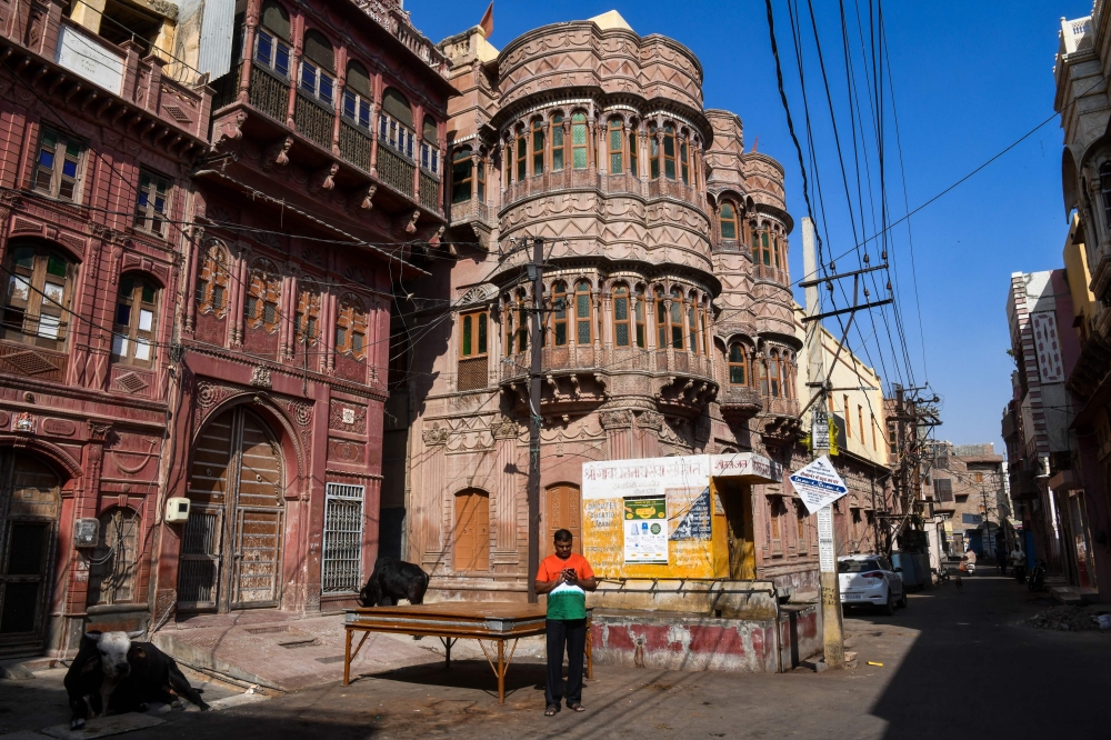 In this photograph taken on December 5, 2018, an Indian man walks past a haveli (mansion) in the old quarters of Bikaner, in the Indian state of Rajasthan.  AFP / Chandan Khanna 
