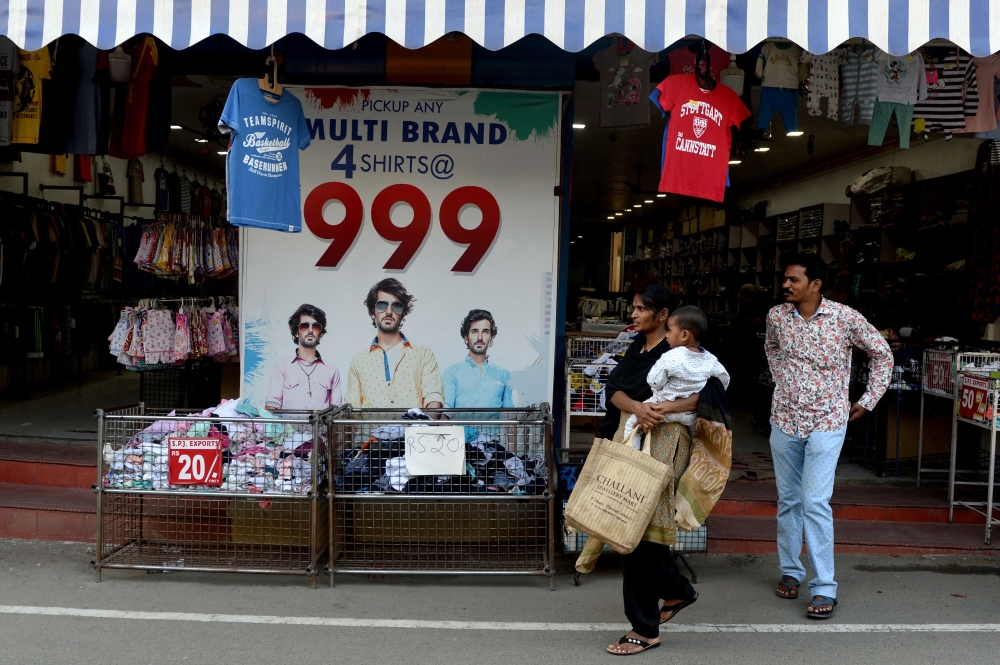 In this photo taken on March 25, 2019, Indian residents leave a clothing shop at the Kadherpettai wholesale textile market in the south Indian city of Tiruppur. AFP / Arun Sankar