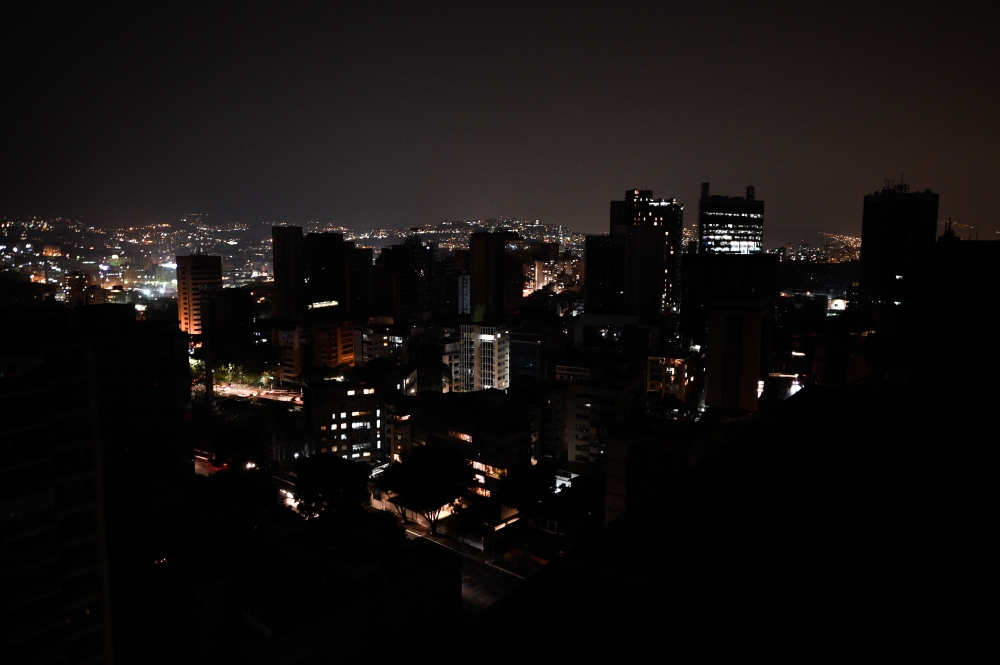 (FILES) This file photo taken on March 26, 2019, shows a general view of Altamira neighborhood partially illuminated during a power outage in Caracas, Venezuela. AFP / FEDERICO PARRA
