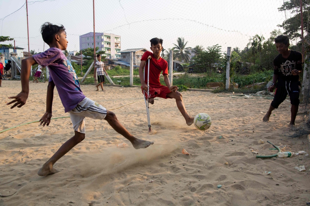 This photo taken on April 2, 2019 shows Kaung Khant Lin (R) fighting for the ball during a football match in Yangon. Football-mad Myanmar teen Kaung Khant Lin roots for Manchester United, worships star Lionel Messi and was honoured as the best player in a