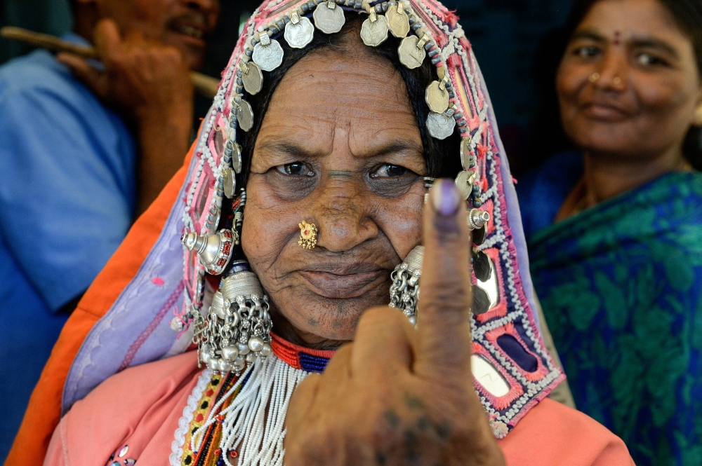 An Indian lambadi tribeswoman shows her ink-marked finger after voting at a polling station during India's general election at Pedda Shapur village on the outskirts of Hyderabad on April 11, 2019. AFP / NOAH SEELAM