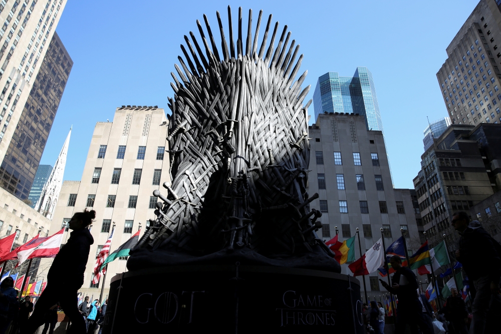 FILE PHOTO: People walk past a large replica of the iron throne before the premiere of the final season of 