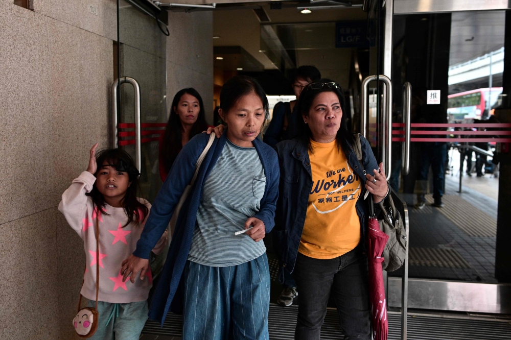 Baby Jane Allas (C), a 38-year-old mother of five Filipina domestic worker who was sacked after she was diagnosed with cervical cancer leaves with family members and supporters after a hearing at the Labour Tribunal in Hong Kong on April 15, 2019, which o
