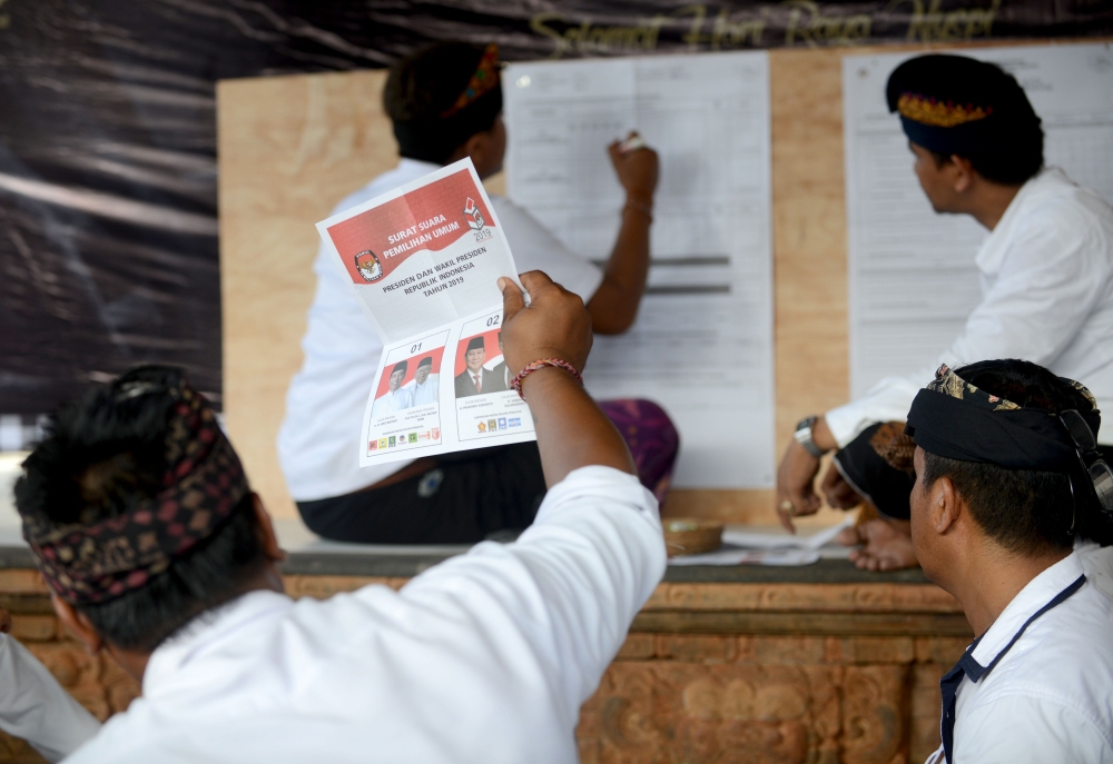 Officials count ballots at a polling centre after the polls closed for the country's general election in Kuta, near Denpasar, on Indonesia's resort island of Bali on April 17, 2019. AFP / SONNY TUMBELAKA