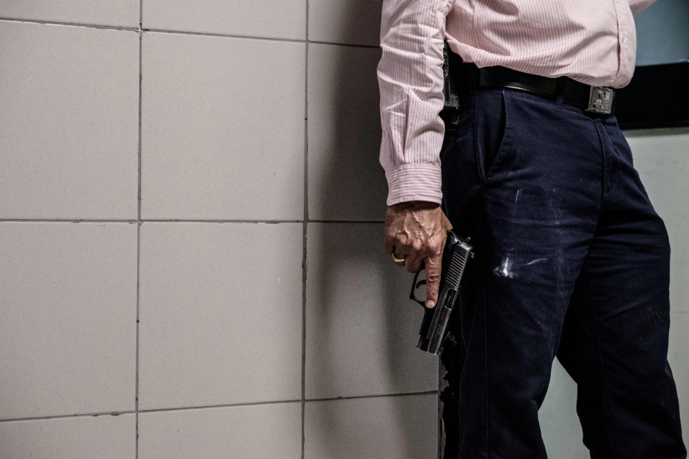 FILE PHOTO: A security officer holds a gun in the building attached to the DusitD2 compound in Nairobi on January 15, 2019 after a blast followed by a gun battle rocked the upmarket hotel complex. AFP/Kabir Dhanji