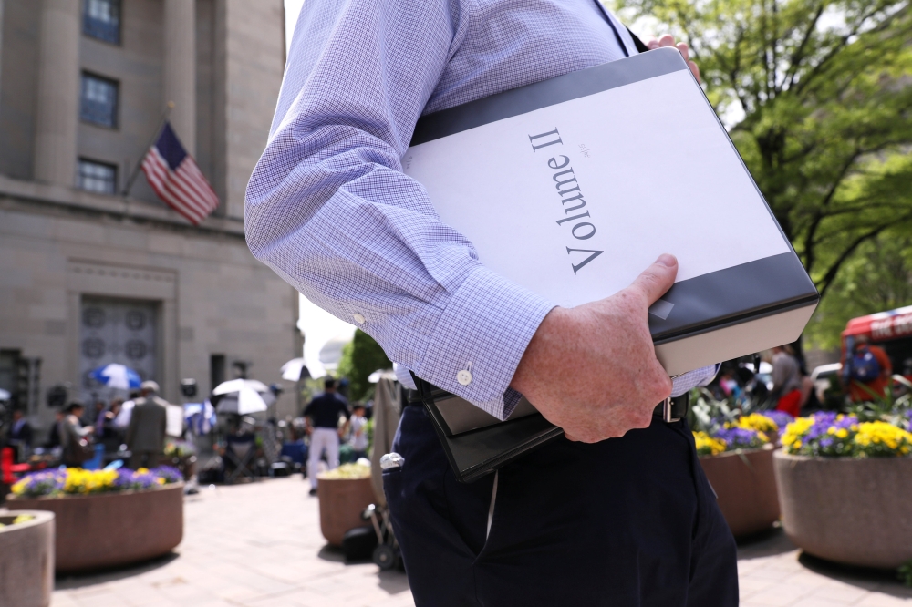 A reporter departs with his official copy of Special Counsel Robert Mueller's report on Russian interference in the 2016 U.S. presidential election, outside the Department of Justice in Washington, U.S., April 18, 2019. Reuters/Jonathan Ernst