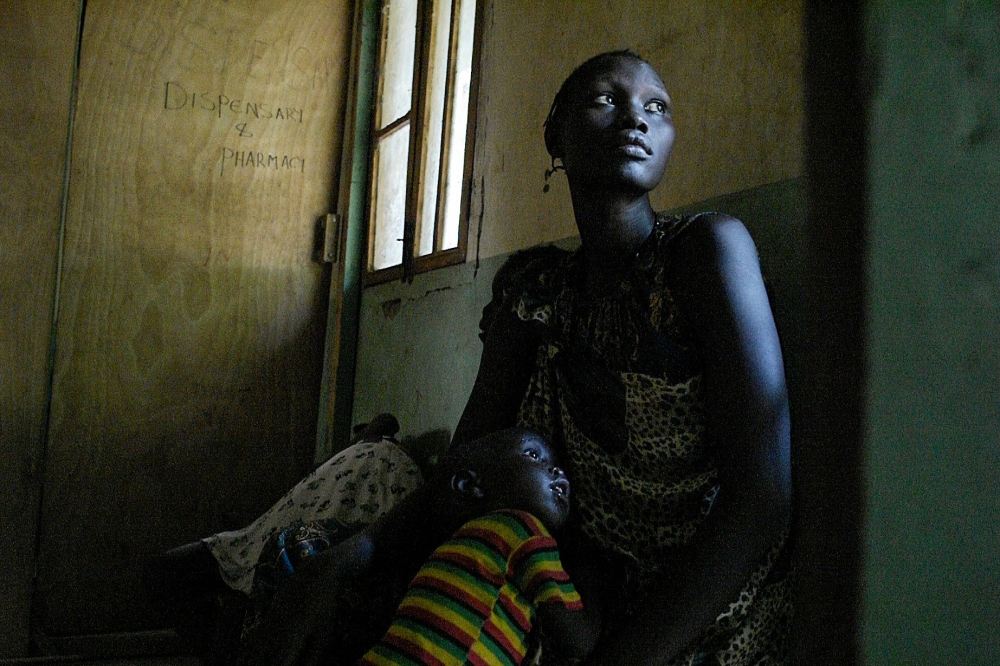 A mother and her sick son wait for treatment at the Udier primary health and care center supported by the International Committee of the Red Cross (ICRC) in Udier, in the Upper Nile region, on March 7, 2019.  AFP / Simon Maina 