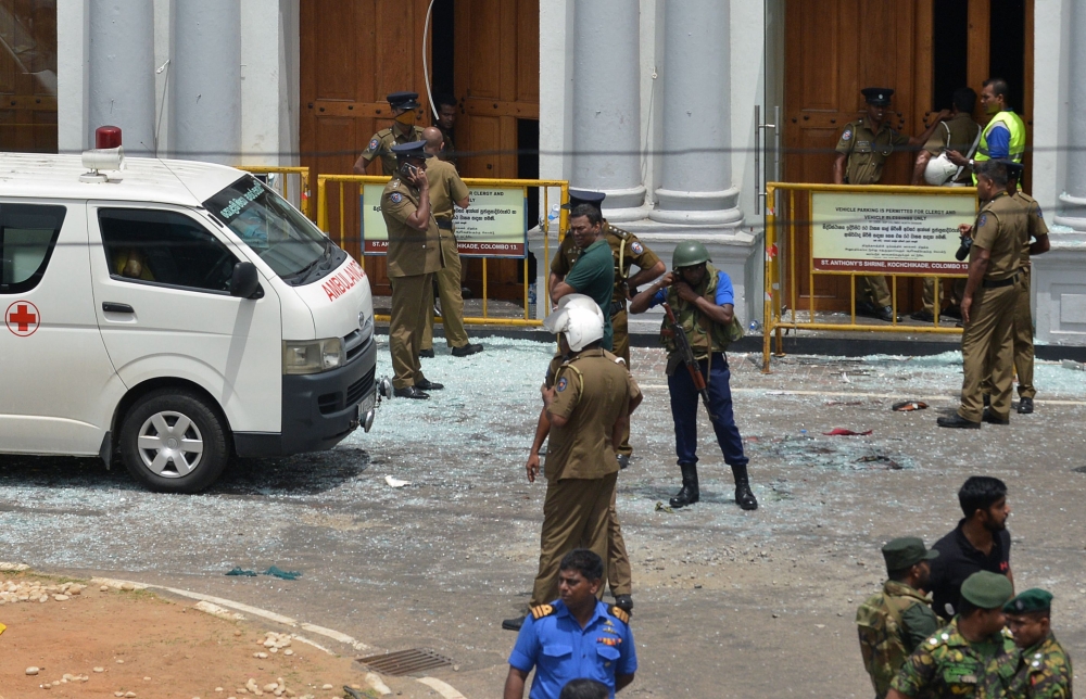 Sri Lankan security personnel stand next to an ambulance outside St. Anthony's Shrine in Kochchikade in Colombo on April 21, 2019 following a blast at the church. / AFP / ISHARA S. KODIKARA 