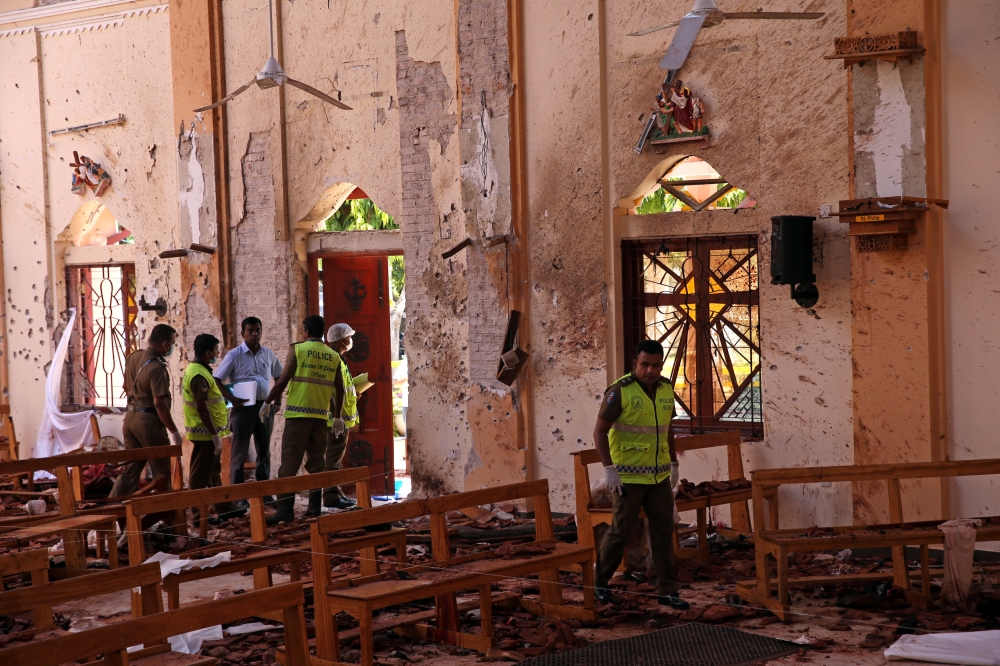 Police officers work at the scene at St. Sebastian Catholic Church, after bomb blasts ripped through churches and luxury hotels on Easter, in Negambo, Sri Lanka April 22, 2019. REUTERS/Athit Perawongmetha