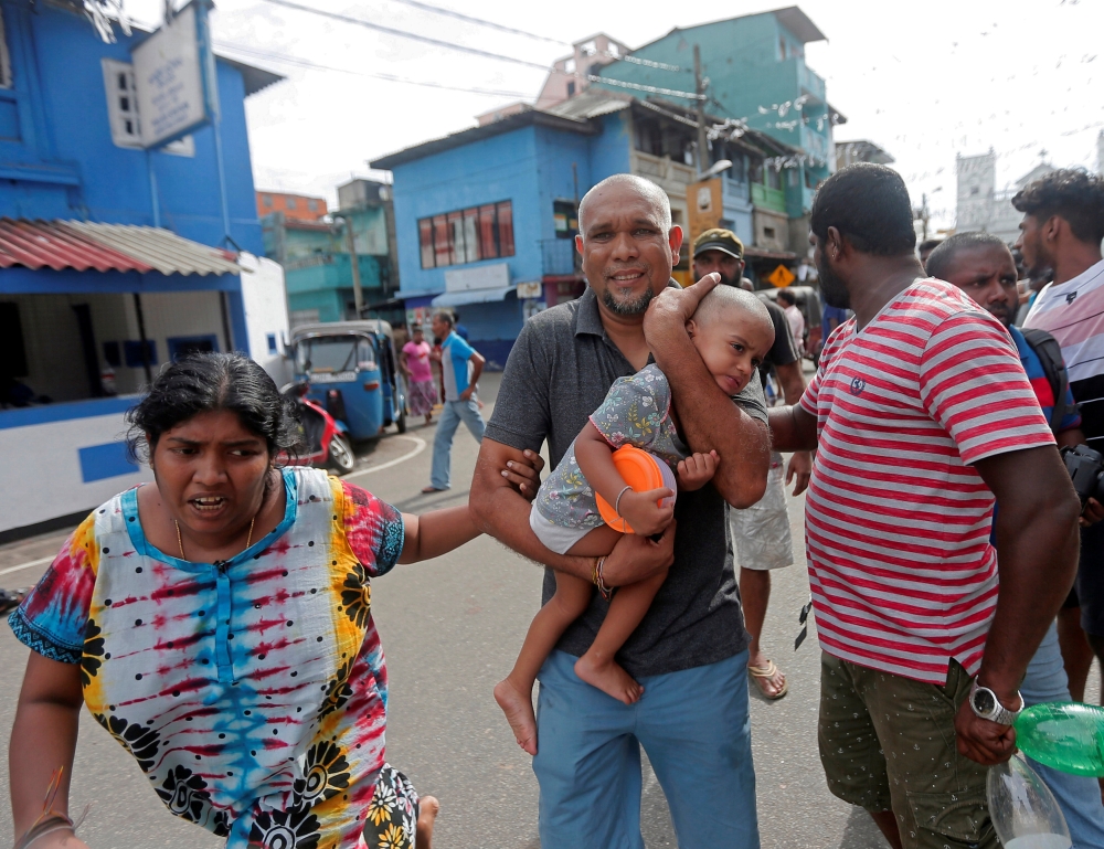 A family who lives near the church that was attacked yesterday, leave their house as the military try to defuse a suspected van before it exploded, in Colombo, Sri Lanka April 22, 2019. Reuters/Dinuka Liyanawatte
 