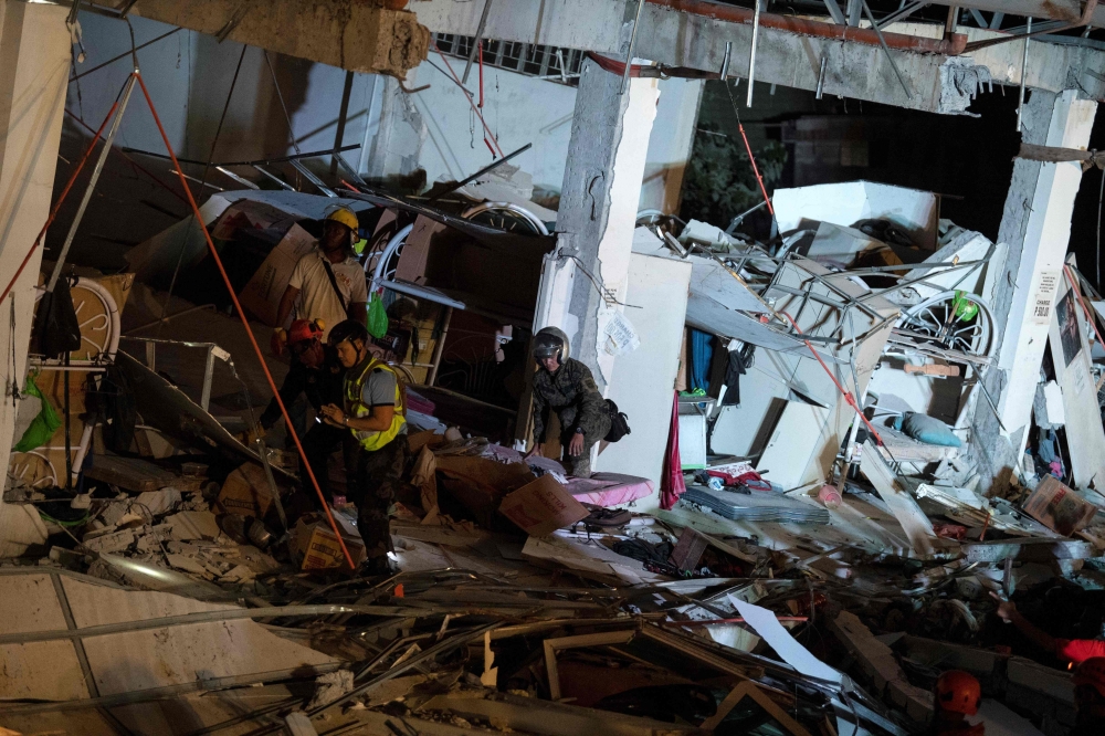 Rescue workers search for survivors in a collapsed Chuzon Super Market in Porac, Pampanga, after a powerful earthquake hit northern Philippines on April 22, 2019. / AFP / Noel CELIS
 