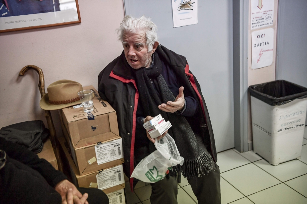 Retired tenor Achilleas Papadopoulos holds the medicines he received at the social pharmacy of Elliniko in this picture taken on February 27, 2019. AFP / Aris Messinis 