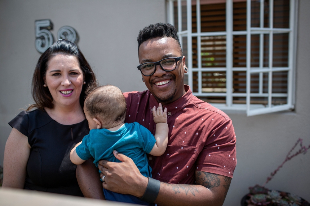 (L to R) Cheryl (31), Camden (6 months) and Mpho Mojapelo (35) pose in their home in Johannesburg on March 7, 2019.  AFP / Gulshan Khan
 