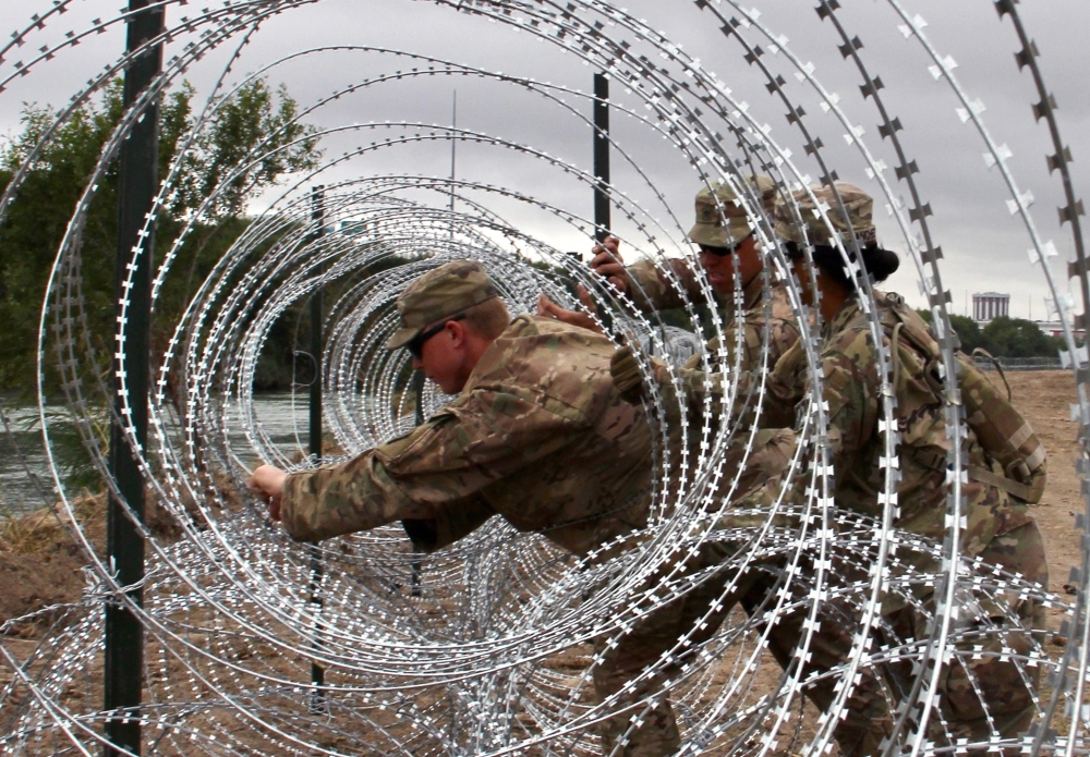FILE PHOTO: Soldiers from the Kentucky-based 19th Engineer Battalion install barbed wire fences on the banks of the Rio Grande in Laredo, Texas. November 18, 2018. AFP / Thomas WATKINS