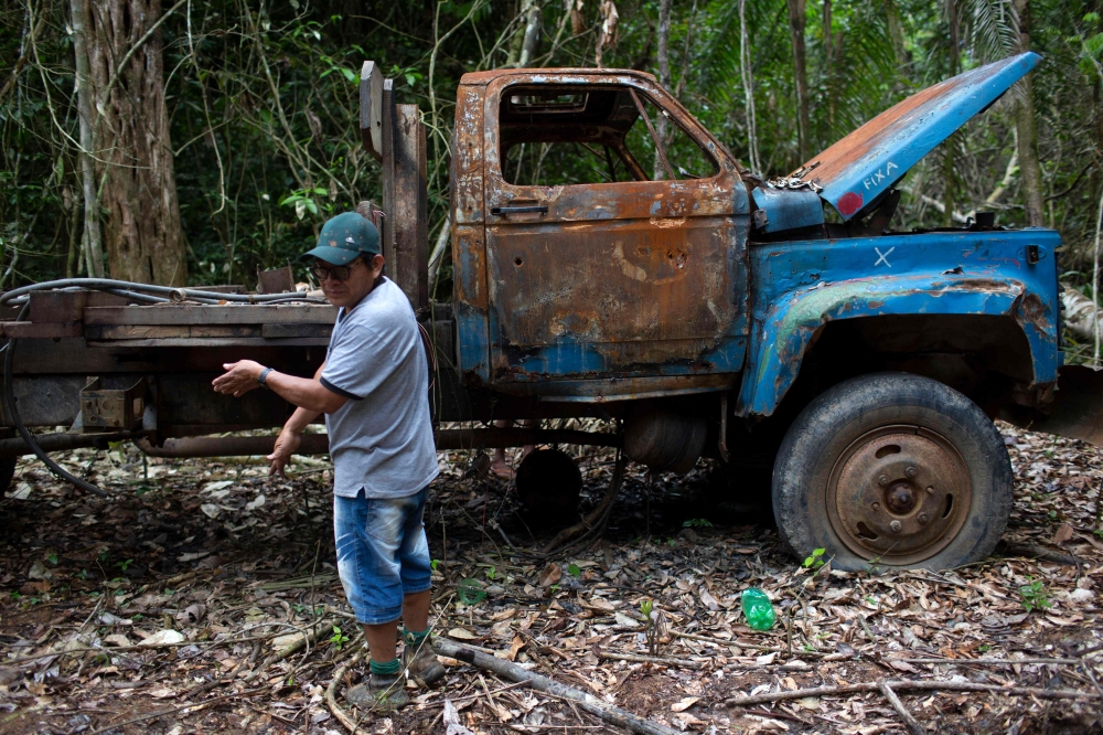 Arara indigenous chielf Motjibi, 43, stands next to a burnt truck as he patrols the Arara indigenous land, in Para state, Brazil on March 13, 2019.  AFP / Mauro Pimentel 