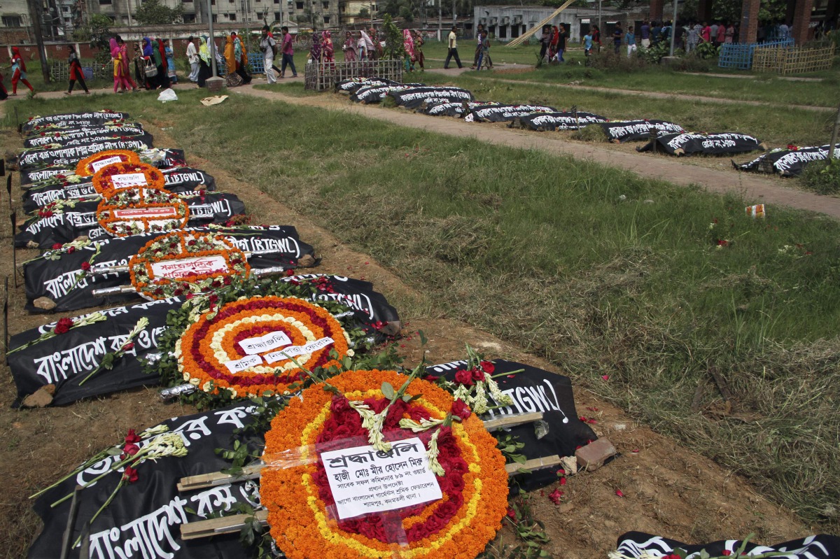 Relatives of victims of the Rana Plaza building collapse pay their respects at a graveyard in Dhaka on April 24, 2016. AFP/Rehman Asad