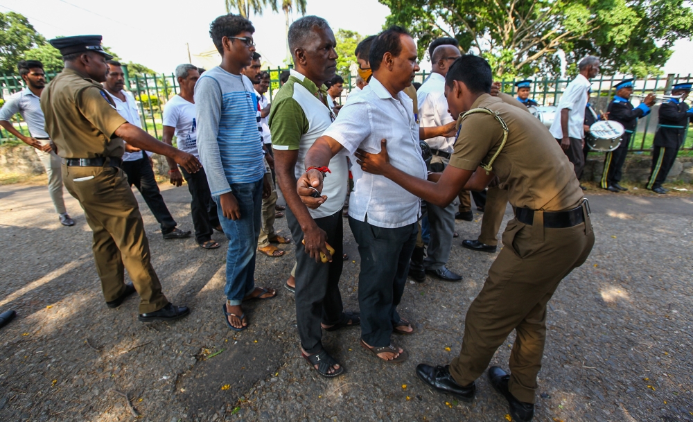 People pass from a checkpoint to attend funeral ceremony at Madampitiya cemetery for the victims of multiple terror attacks in Colombo, Sri Lanka on April 24, 2019. Chamila Karunarathne - Anadolu 

