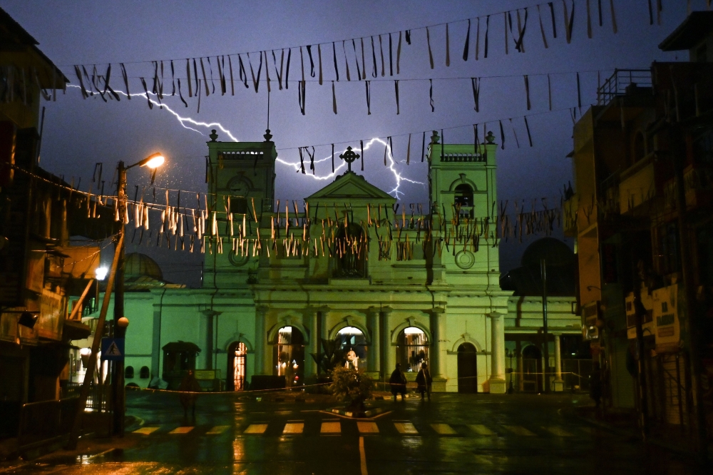 Lightning strike in the sky over St. Anthony's Shrine in Colombo on April 25, 2019, as soldiers stand guard following a series of bomb blasts targeting churches and luxury hotels on the Easter Sunday in Sri Lanka.  AFP / Jewel Samad
 