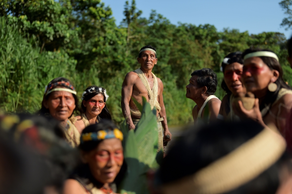 Waorani indigenous people sail in a canoe in the Curaray river, near the village of Nemompare, in Pastaza province, Ecuador on April 14, 2019.  / AFP / RODRIGO BUENDIA 