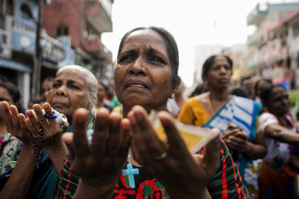 Sri Lankan Christian devotees pray at a barricade near St. Anthony's Shrine in Colombo on April 28, 2019, a week after a series of bomb blasts targeting churches and luxury hotels on Easter Sunday in Sri Lanka. AFP / Jewel Samad 
