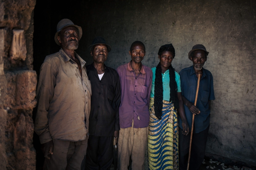 Elderly men and women, employed by the JTN tea plantation, pose for a photograph in the courtyard of the tea processing plant, near Mweso, in the Masisi Territory, North Kivu province, eastern DR Congo, on April 11, 2019. AFP / Alexis Huguet 