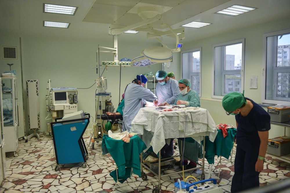 Romanian surgeons and assistant personnel are pictured inside an operation room during medical procedures at the local hospital in the eastern town of Slobozia March 27, 2019.  AFP / Daniel Mihailescu
 