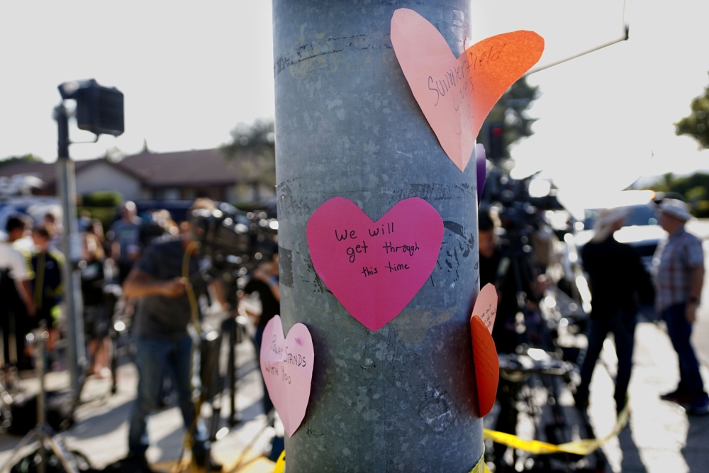  Hand-written notes are displayed on a light post across the street from the Chabad of Poway Synagogue after a shooting on April 27, 2019 in Poway, California. AFP / Sandy Huffaker
 