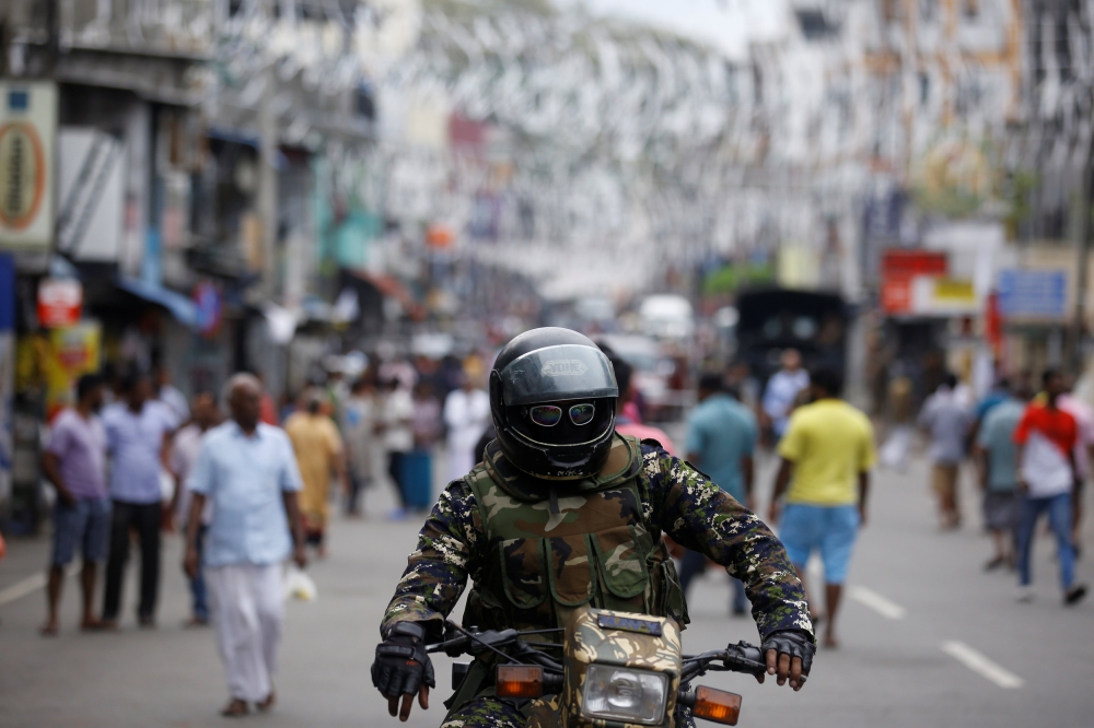A member of the Sri Lankan security forces sits on a motorbike as he keeps watch outside St Anthony's Shrine, days after a string of suicide bomb attacks across the island on Easter Sunday, in Colombo, Sri Lanka April 28, 2019. REUTERS/Thomas Peter
