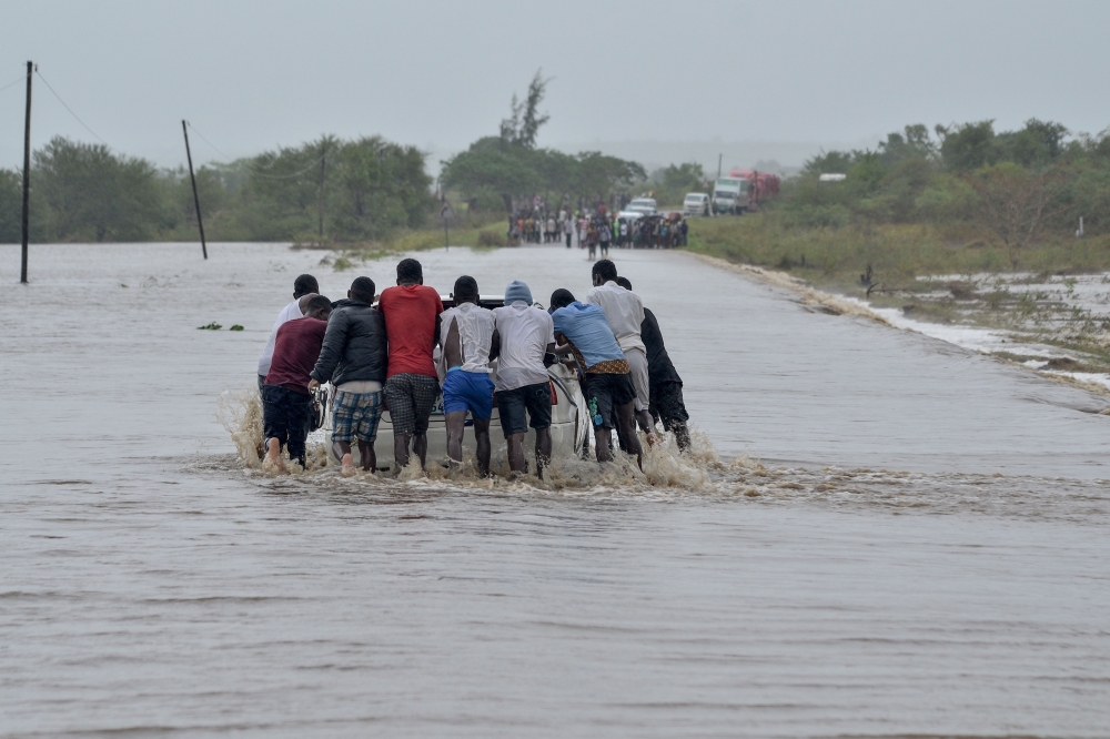 Residents push a car through the floods in Mazive, southern Mozambique, on April 28, 2019. AFP / Emidio Josine
