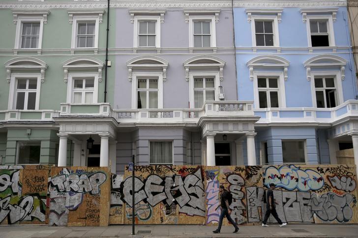 People walk past boarded-up houses ahead of the Notting Hill, Carnival in London, Britain, August 27 2016. Reuters/Neil Hall