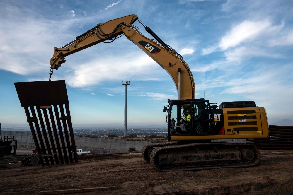 A construction crew works on replacing the US-Mexico border fence as seen from Tijuana in Baja, California state on January 9, 2019. AFP/Guillermo Arias
