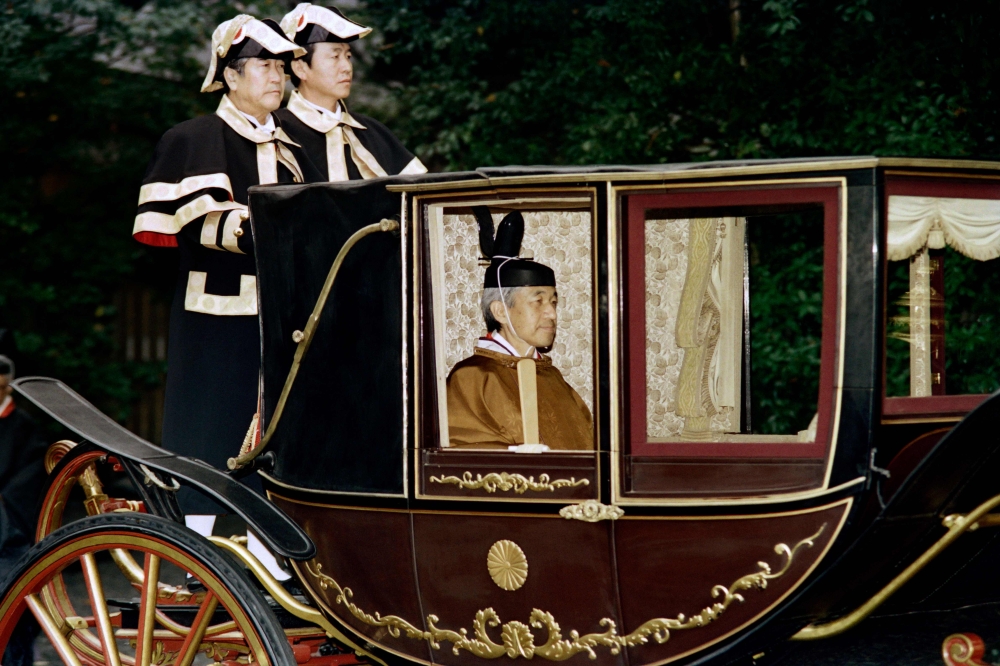 In this file photo taken on November 28, 1990 Japanese Emperor Akihito sits in a carriage on his way to visit the inner shrine at Ise.  AFP / Toshifumi Kitamura