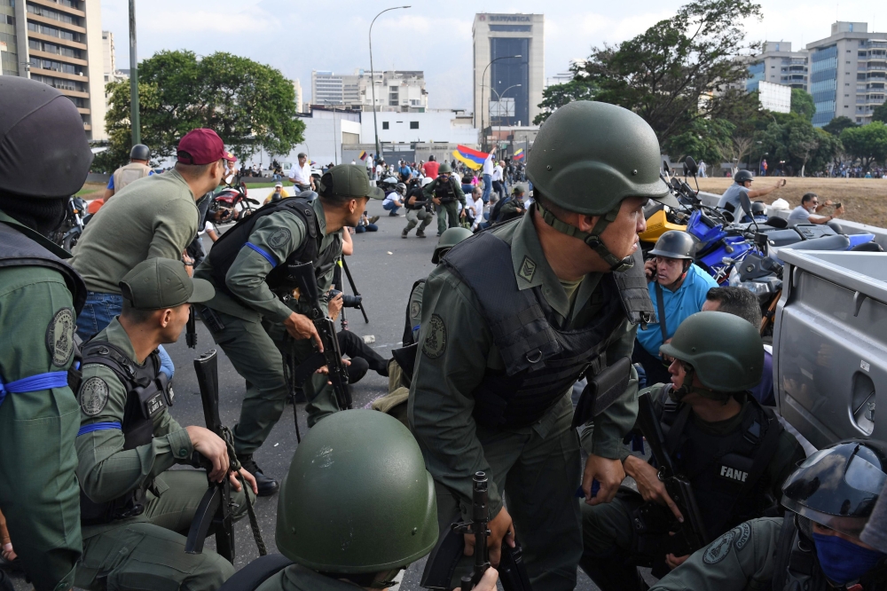 Members of the Bolivarian National Guard loyal to Venezuelan opposition leader and self-proclaimed acting president Juan Guaido take position in front of La Carlota base in Caracas on April 29, 2019. AFP / Yuri CORTEZ