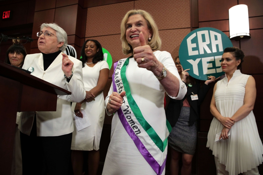 U.S. Rep. Carolyn Maloney (D-NY) (C) holds a thumbs up as National Organization for Women President Toni Van Pelt (L), President and co-founder of the Feminist Majority Foundation Eleanor Smeal (2nd L), and Actress Alyssa Milano (R) attend a news conferen