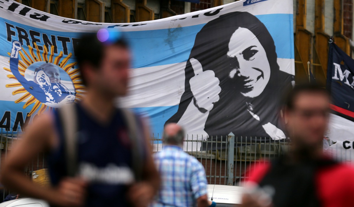 Supporters of Cristina Fernandez de Kirchner stand in front of a banner with her image as they wait for her to leave court in Buenos Aires, October 31, 2016. Reuters/Marcos Brindicci